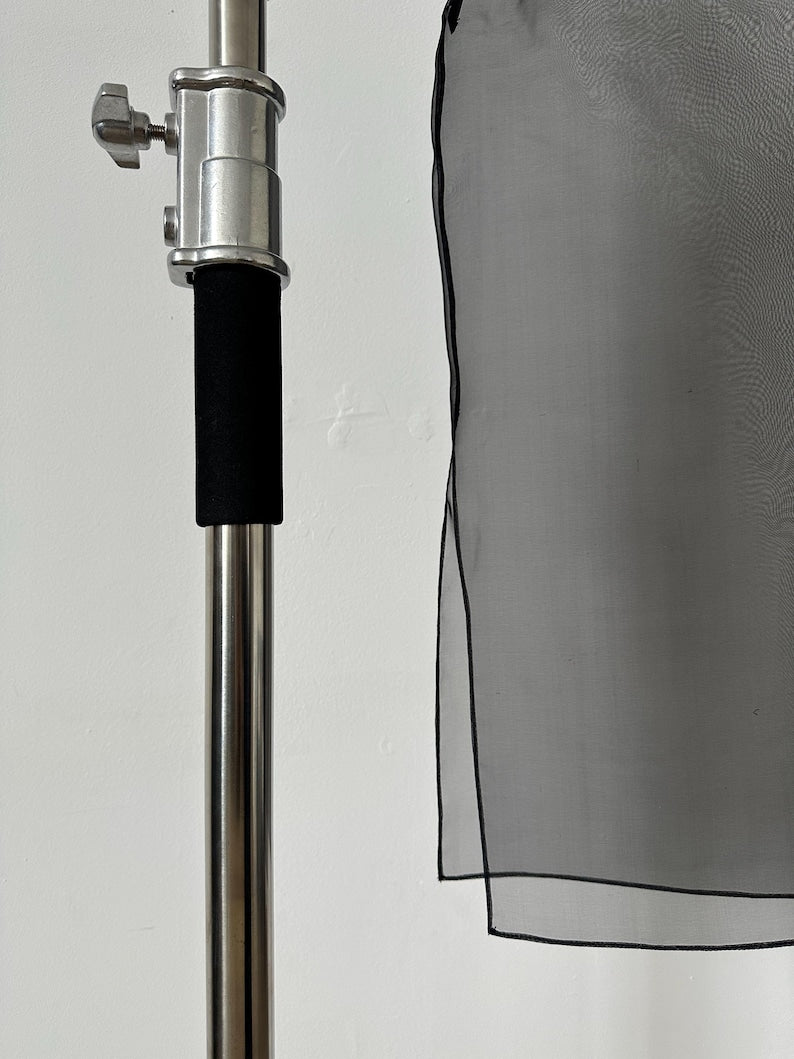 Close-up of sheer black silk organza fabric showing hem detail and texture