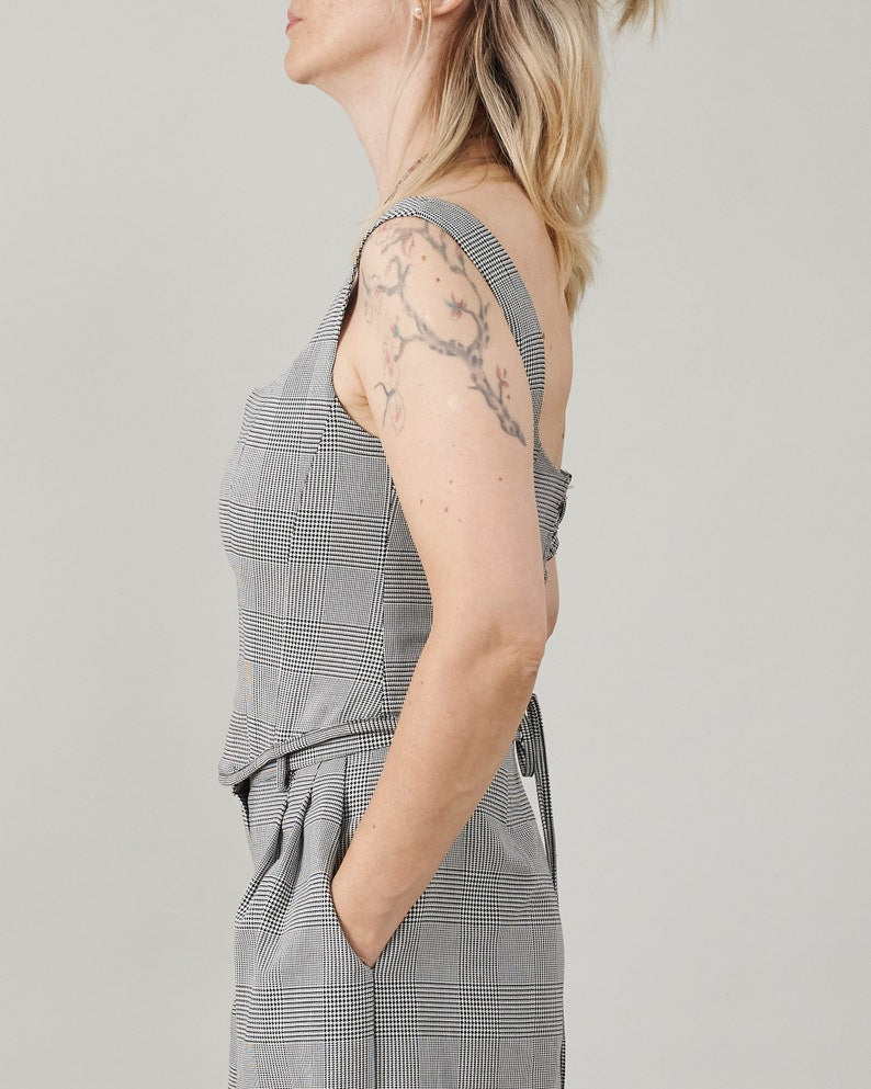 Woman wearing a gray checkered bustier top with a plain background