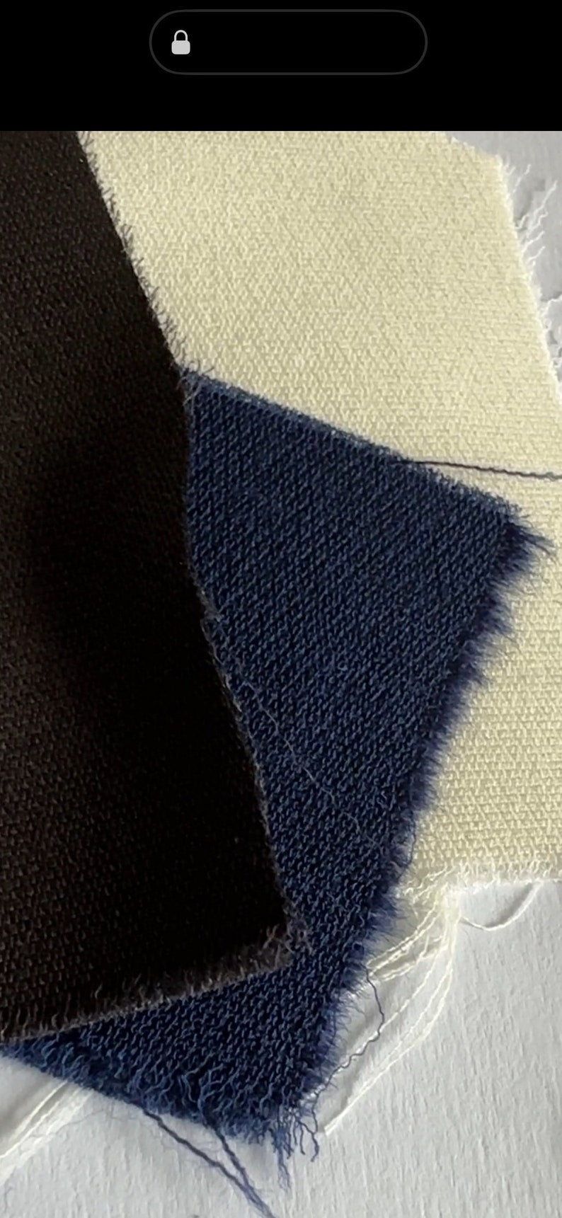 Close-up of dark blue, ivory white and dark brown textured fabric on a light background