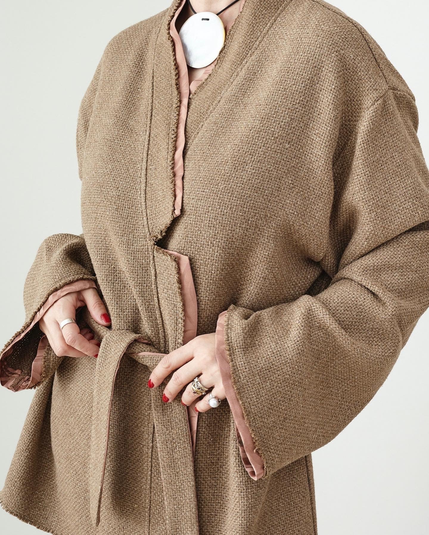 Woman tying the belt of a tailored kimono