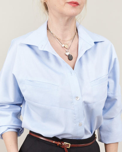 Light blue button-up shirt worn by a person with a neutral background