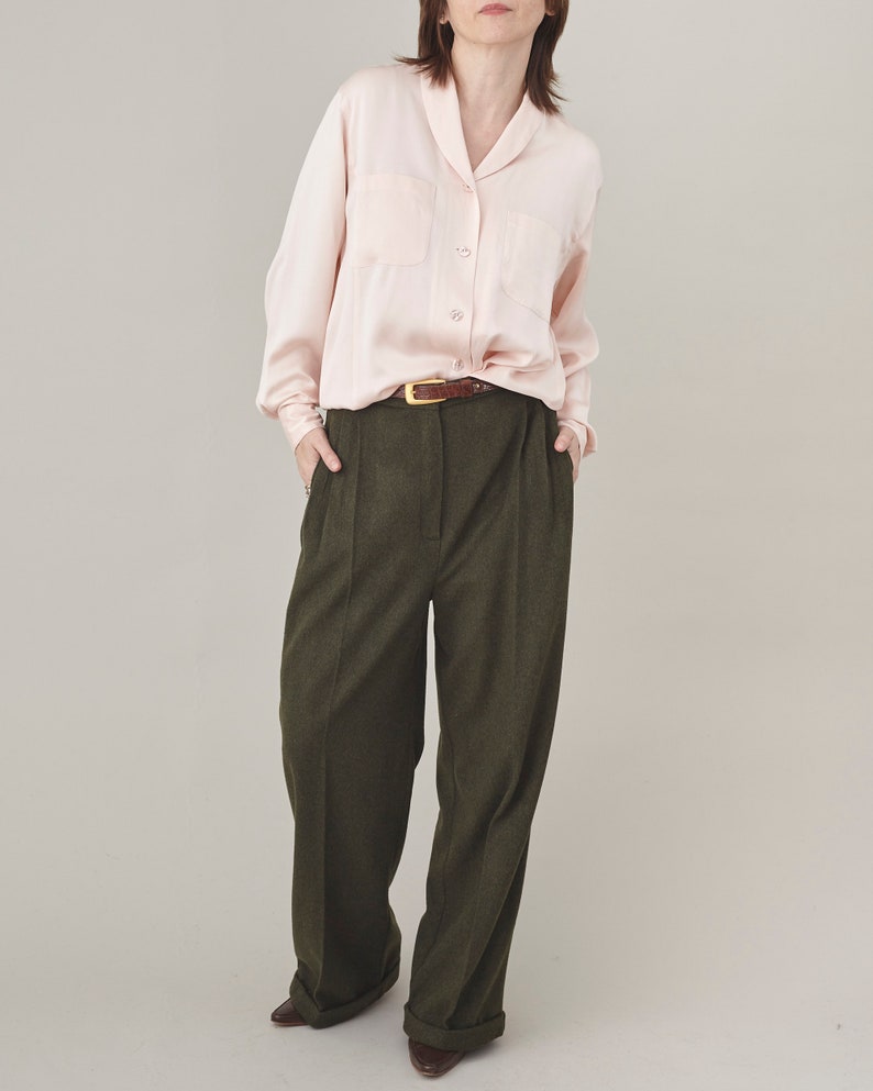 Olive cashmere wide-leg pants styled with a pale pink silk blouse and brown belt.
