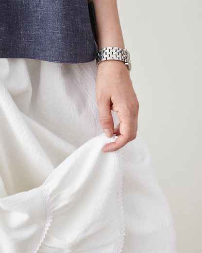 Person holding white fabric with a neutral background