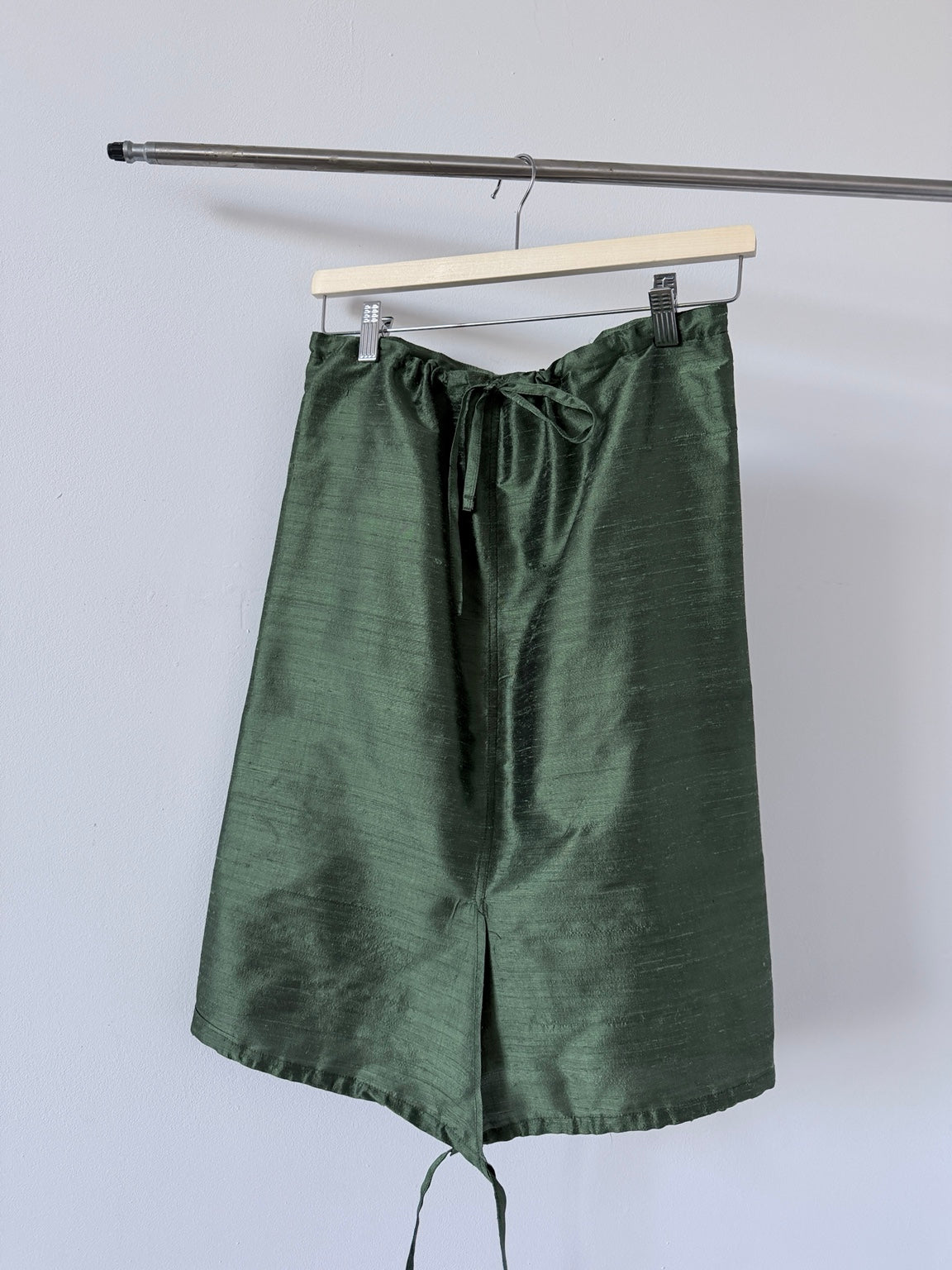 Green silk skirt hanging front view