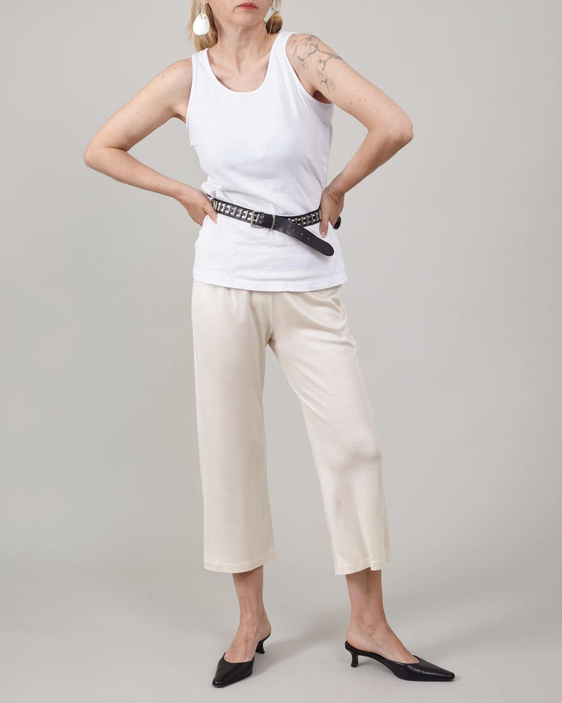 Front view of the ivory cropped version of the silk jersey flare pants.