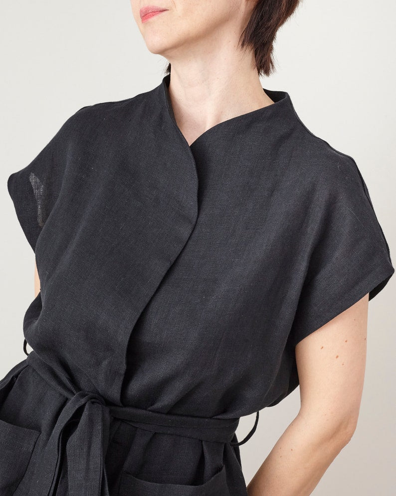 Black wrap dress worn by a person on a plain background