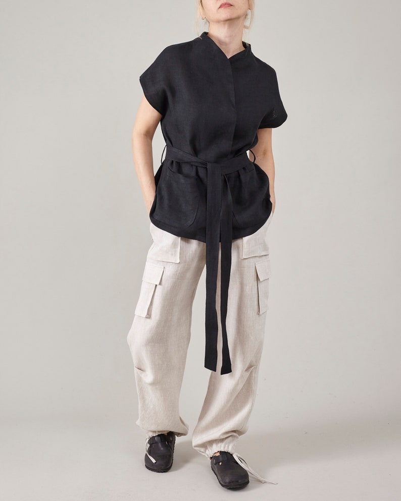 Off-white linen cargo pants styled with a black belted blouse and black shoes.