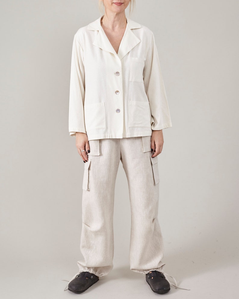 Off-white linen cargo pants worn with a matching relaxed linen shirt.