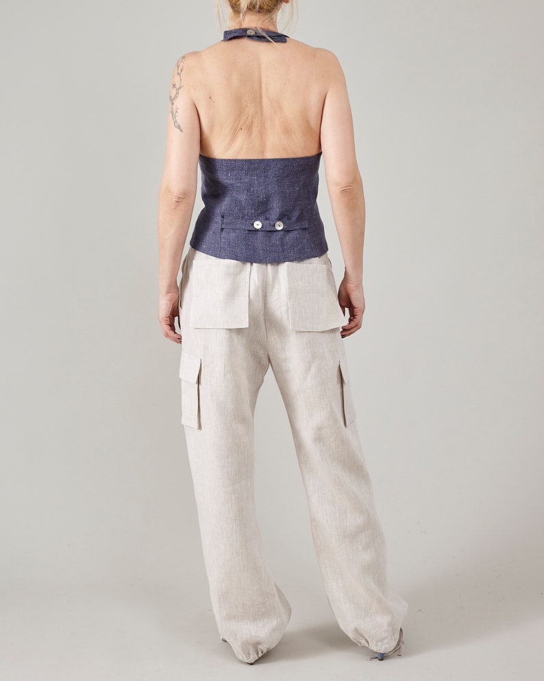 Back view of off-white linen cargo pants showing the relaxed leg and adjustable hems.