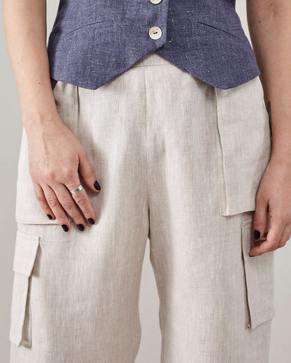 Close-up of the patch and flap pockets on off-white linen cargo pants.