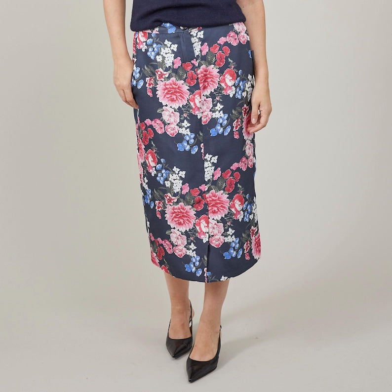 Floral skirt worn by a person on a plain background