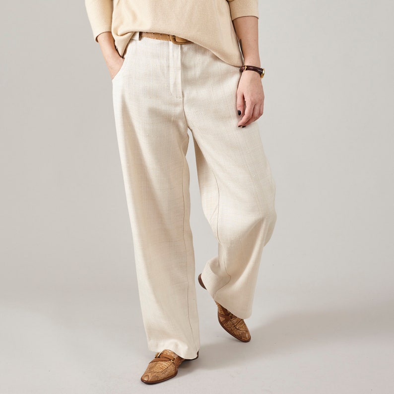 Front view of cream raw silk straight-leg pants with a relaxed fit and side pockets.