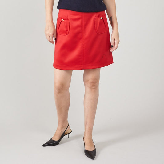 Person wearing a red skirt on a plain background