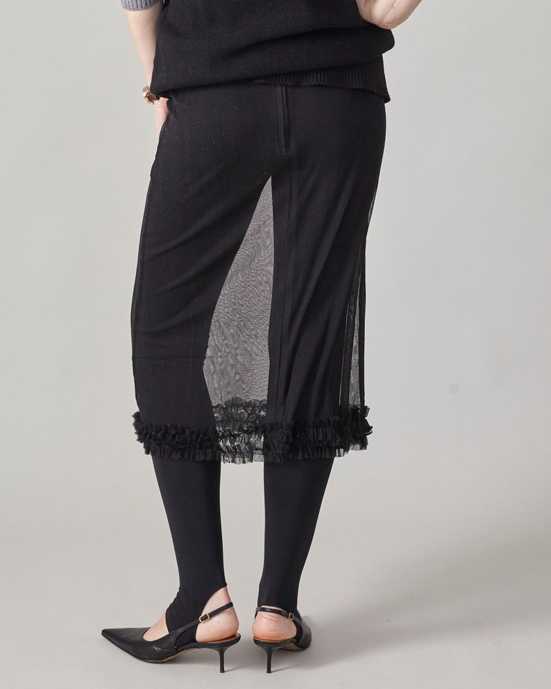 Black sheer skirt with ruffled hem layered over a pair of opaque black tights