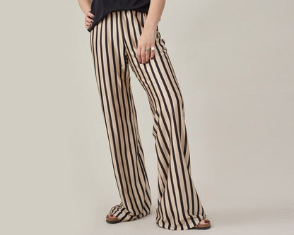 Front view of black and beige striped silk jersey flared pants with an elastic waist.