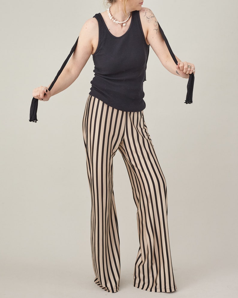 Full-length view of striped silk jersey flared pants showing their fluid movement.