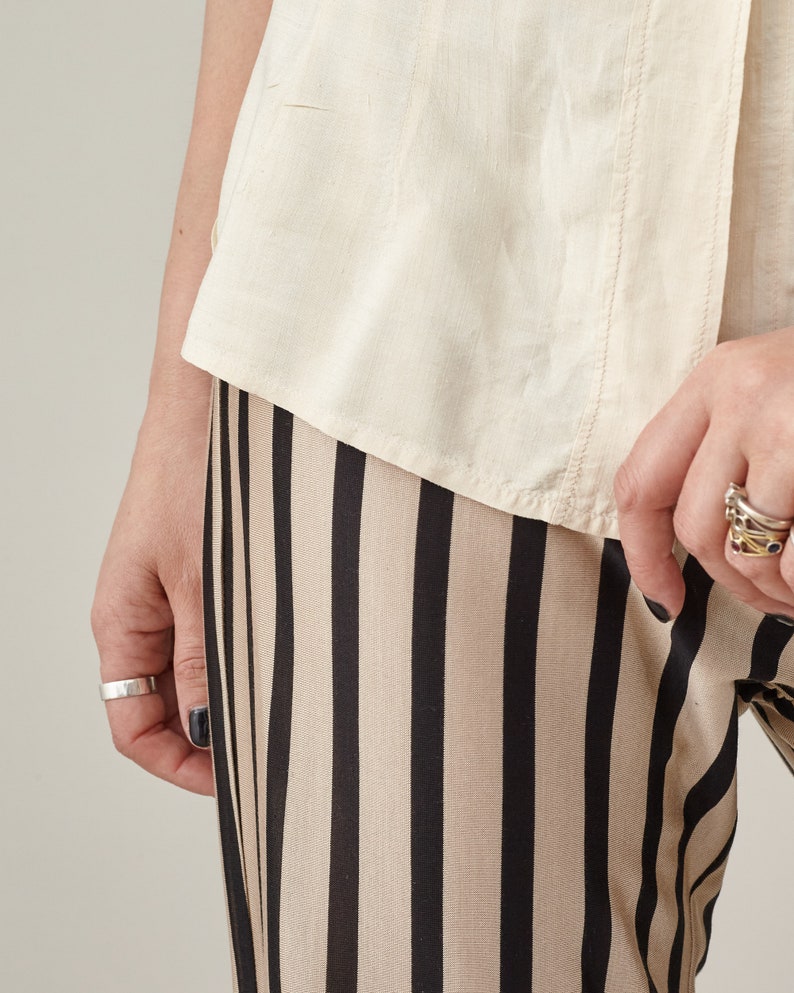Close-up of the elastic waist and vertical stripes on silk jersey flared pants.