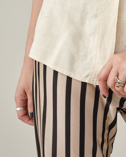 Close-up of the elastic waist and vertical stripes on silk jersey flared pants.