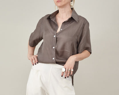 Front view of a taupe silk short-sleeve blouse with a relaxed straight fit and button front.