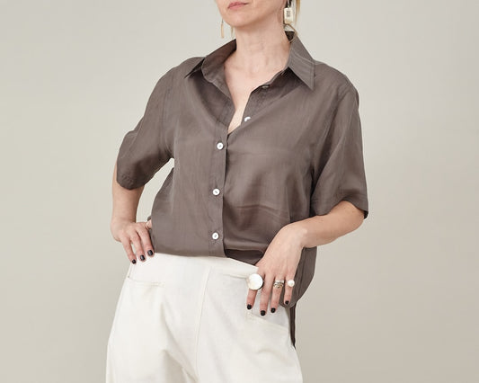 Front view of a taupe silk short-sleeve blouse with a relaxed straight fit and button front.