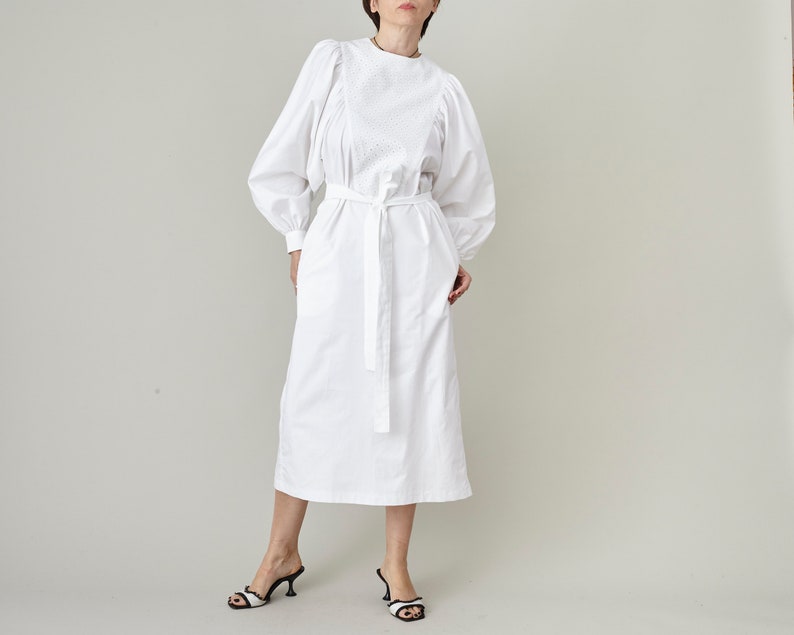 White colorway of the long-sleeve silk midi dress with a tie waist and flowing skirt.