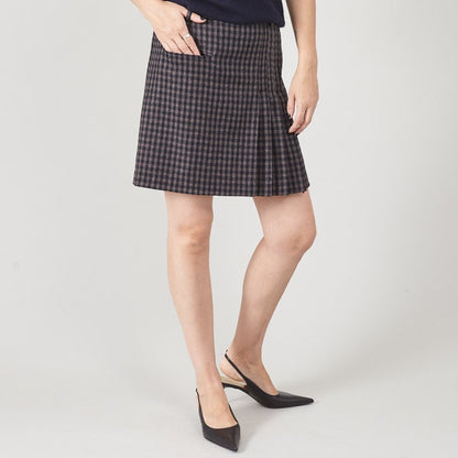Person wearing a black and gray checkered skirt on a white background