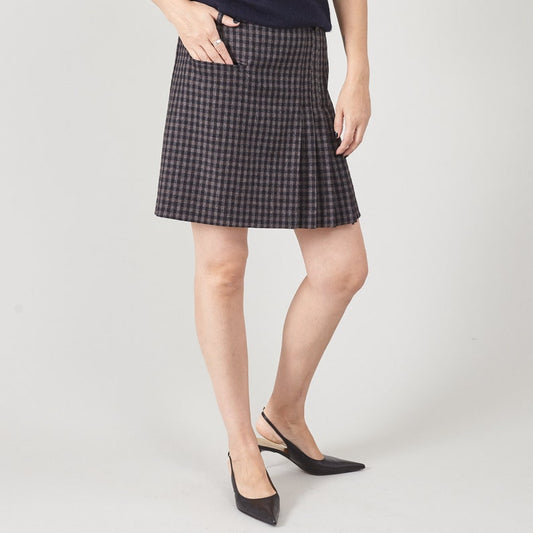 Person wearing a black and gray checkered skirt on a white background