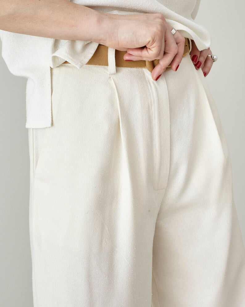 Close-up of high-waisted pleated raw silk trousers showing belt loops, front pleat, and ivory silk texture, handmade by Fine Thee