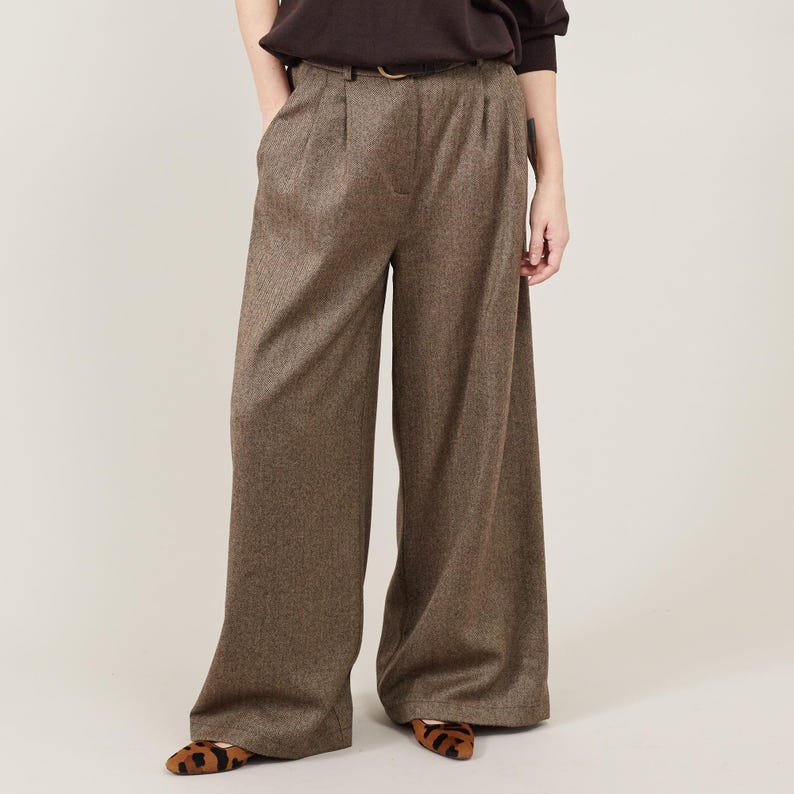 Person wearing brown wide-leg pants on a plain background