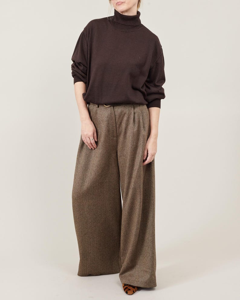 Women’s wide-leg wool pants in brown tweed, high-waist with pleats and flowing palazzo cut, front view; styled with a dark brown turtleneck, Fine Thee.