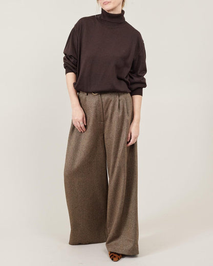 Women’s wide-leg wool pants in brown tweed, high-waist with pleats and flowing palazzo cut, front view; styled with a dark brown turtleneck, Fine Thee.