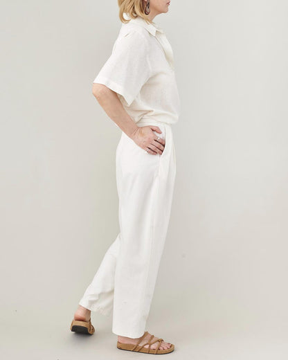 Person wearing a white outfit on a plain background