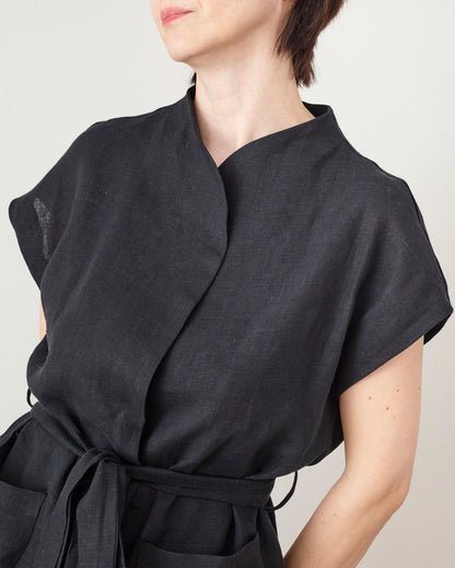Black wrap dress worn by a person on a plain background