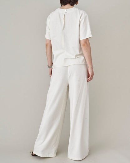 Back view of women's relaxed raw silk wide-leg trousers styled with a matching ivory silk t-shirt by Fine Thee