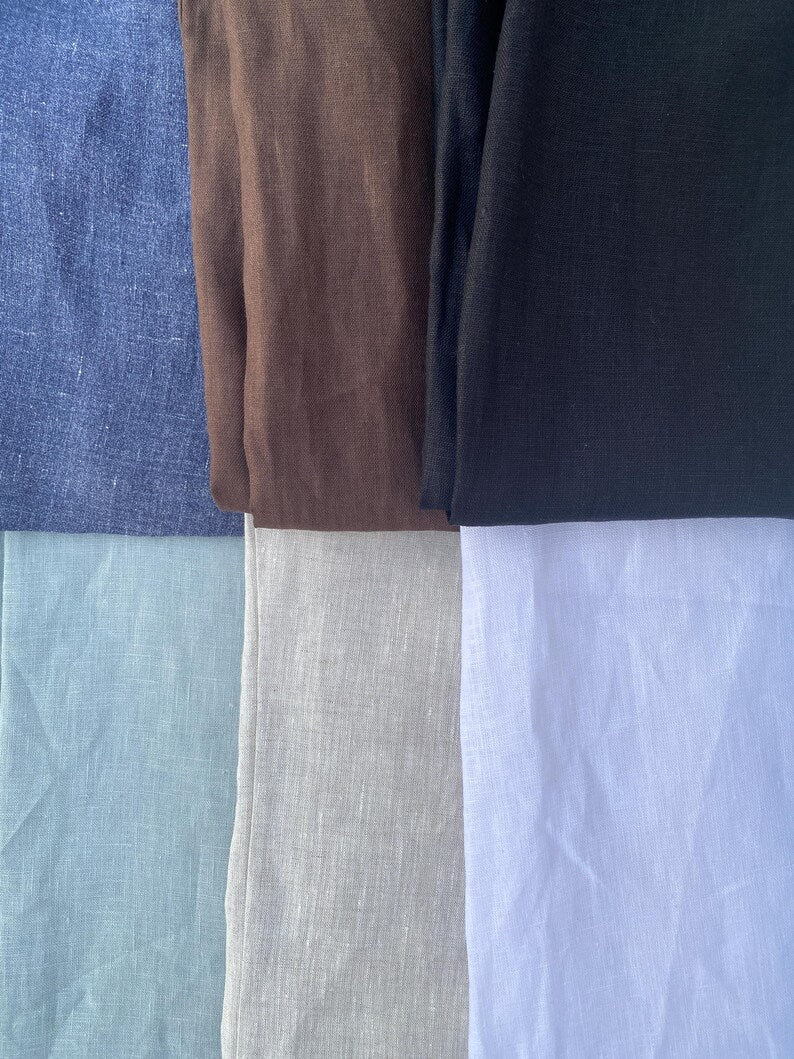Stack of folded fabric swatches in various colors including blue, brown, black, gray, and white.