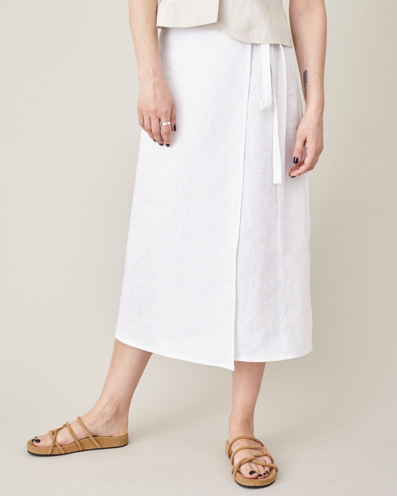 Person wearing a white skirt with a neutral background