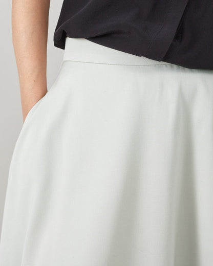Mint skirt waist band and pocket detail on a plain background
