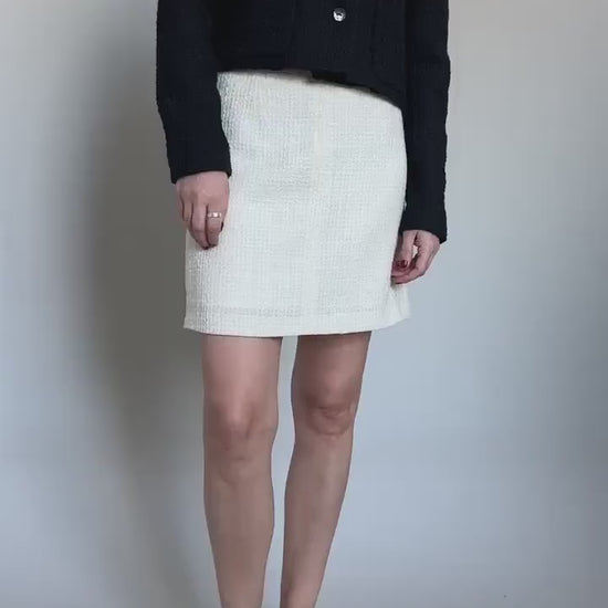 black crop jacket and white mini skirt, both crafted from wool boucle outfit