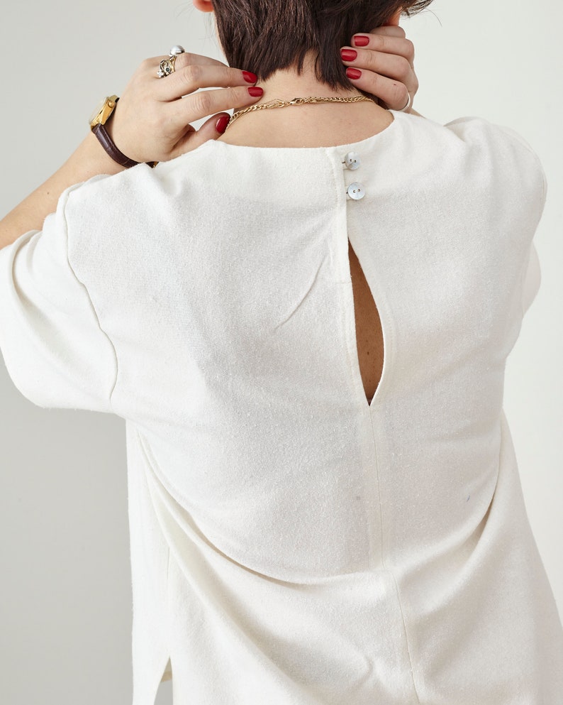 White blouse with mother of pearl buttons at the back neckline 