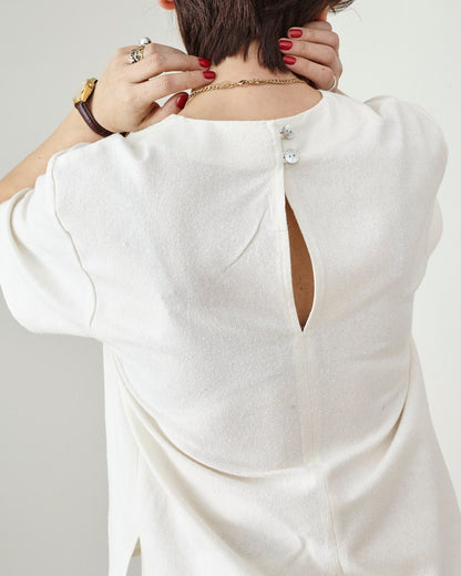 White blouse with mother of pearl buttons at the back neckline 