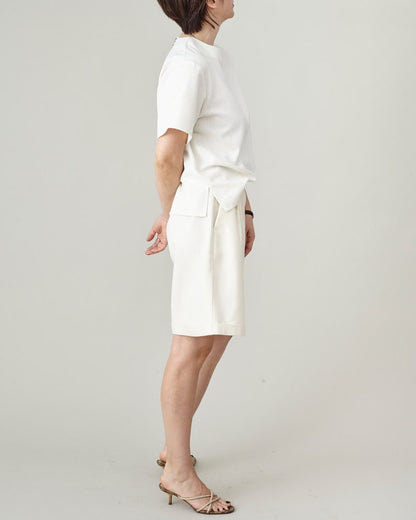 Person wearing a white outfit on a plain background