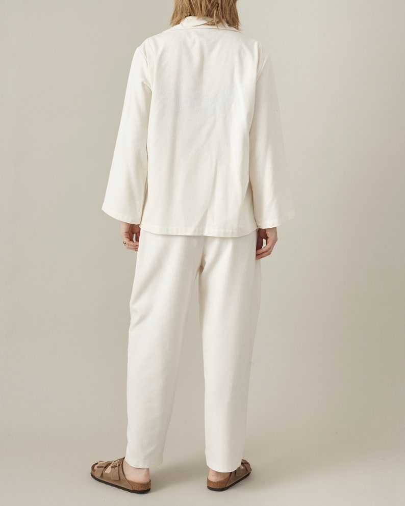 Person wearing a white outfit with a plain background