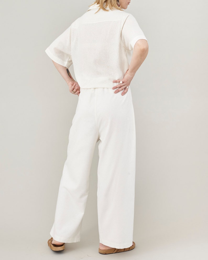 Back view of wide-leg raw silk trousers, showing the flattering drape and back elastic waist