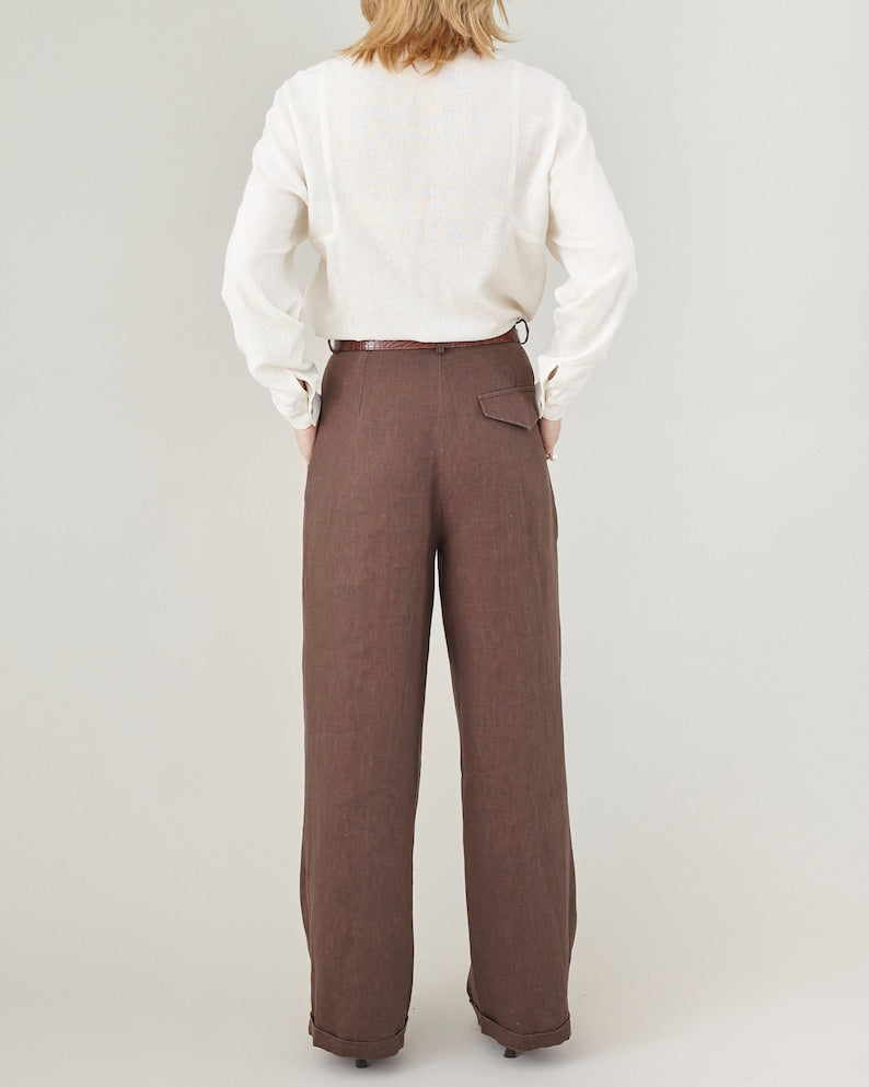 Person wearing a white shirt and brown pants on a plain background