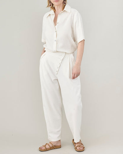 Person wearing a white outfit with a plain background