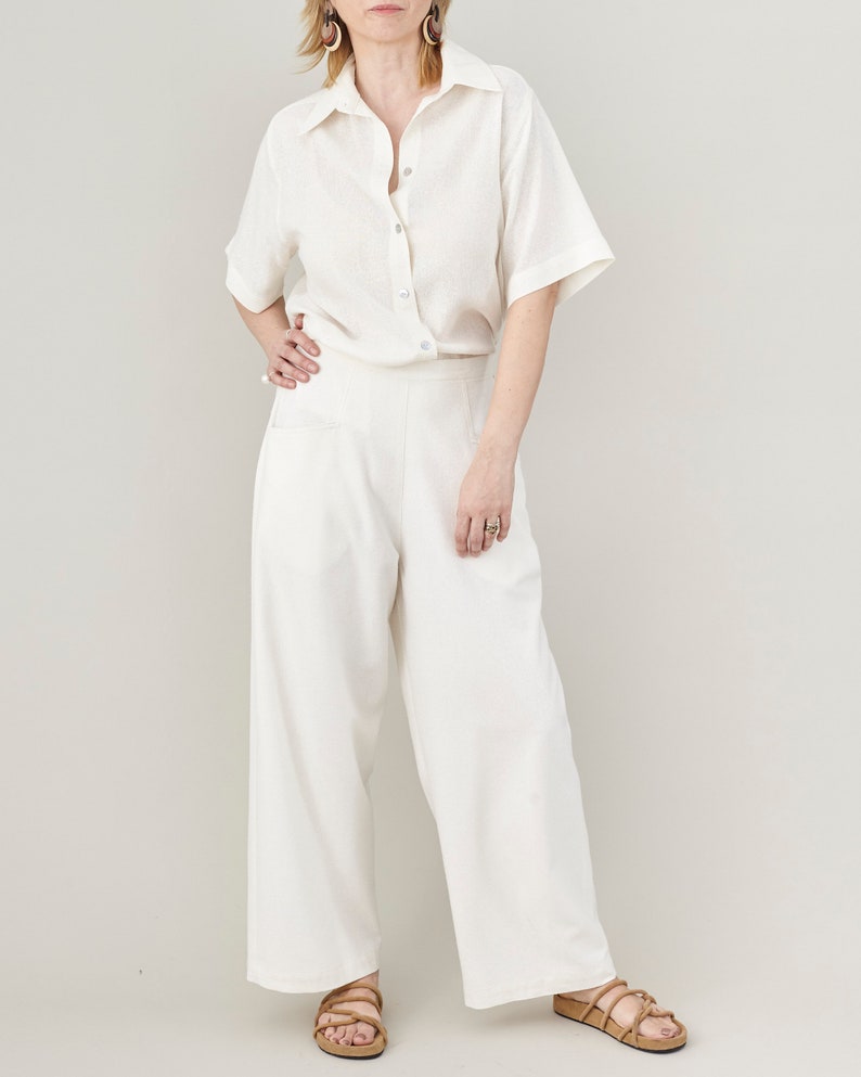 Minimalist wide-leg raw silk trousers styled with a matching oversized short sleeve blouse and beige flat sandals