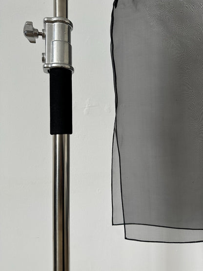 Close-up of sheer black silk organza fabric showing hem detail and texture