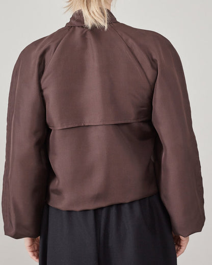 Back cape blouse in chocolate brown shown on light grey background