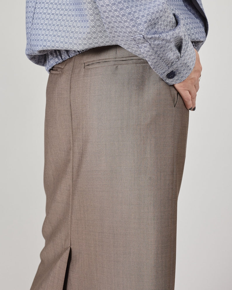 Close-up of greige skirt back pockets with a light gray background
