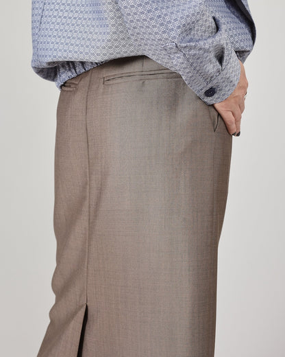 Close-up of greige skirt back pockets with a light gray background